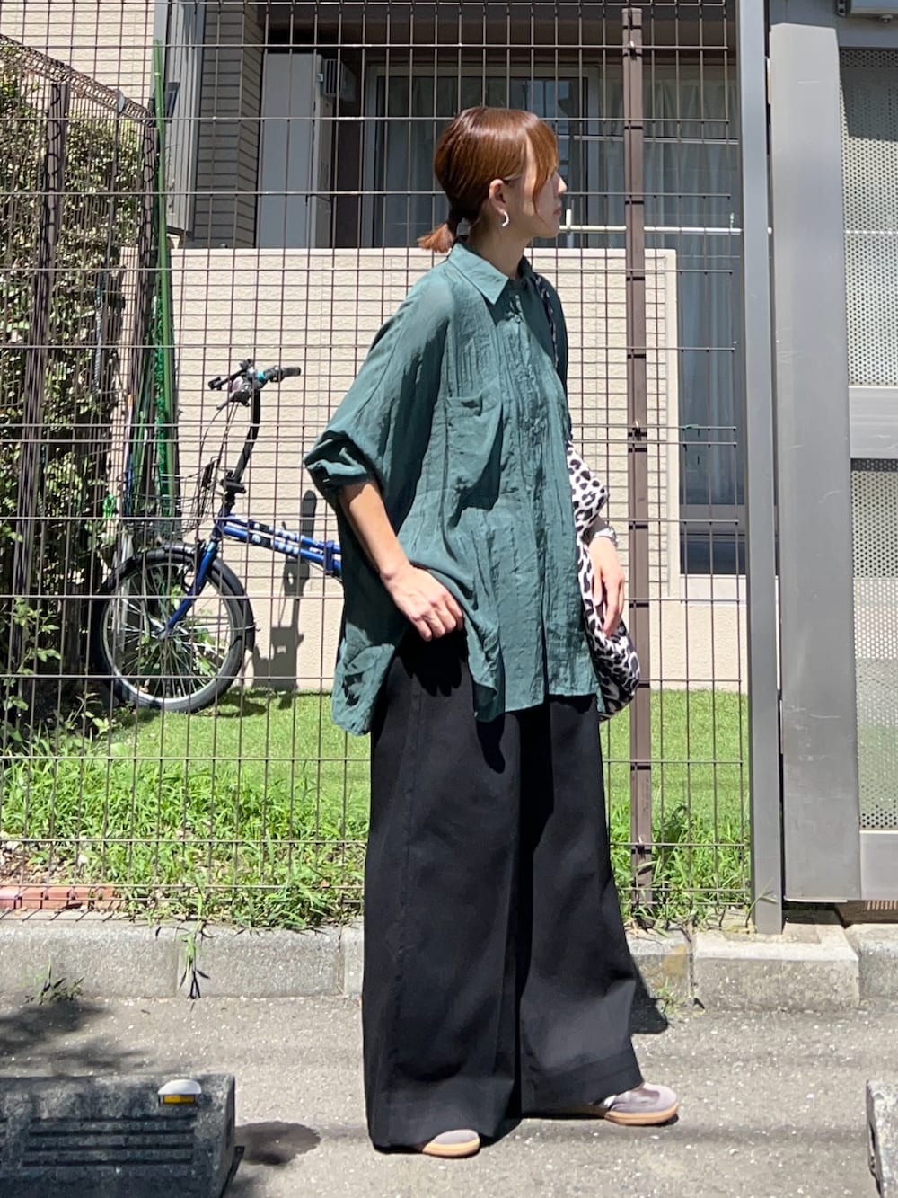 グリーン系のシャツ/ブラウス、ブラック系のベスト、ブラック系のスラックスを着用したレディースの秋コーディネートの4枚目の写真