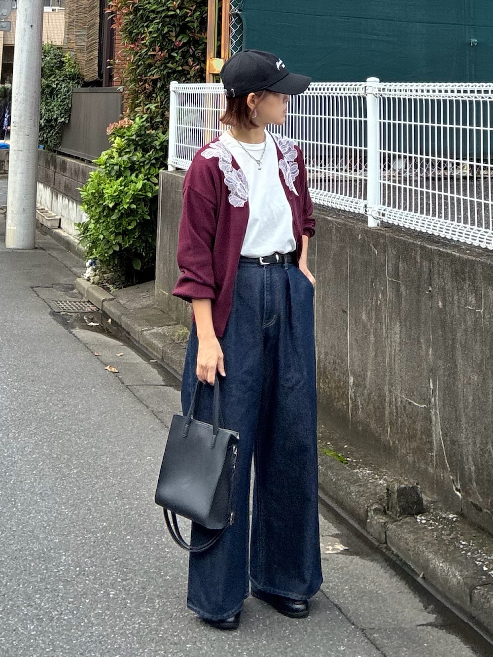 レッド系のカーディガン/ボレロ、ブラック系のTシャツ/カットソー、ブルー系のデニムパンツを着用したレディースの秋コーディネートの4枚目の写真