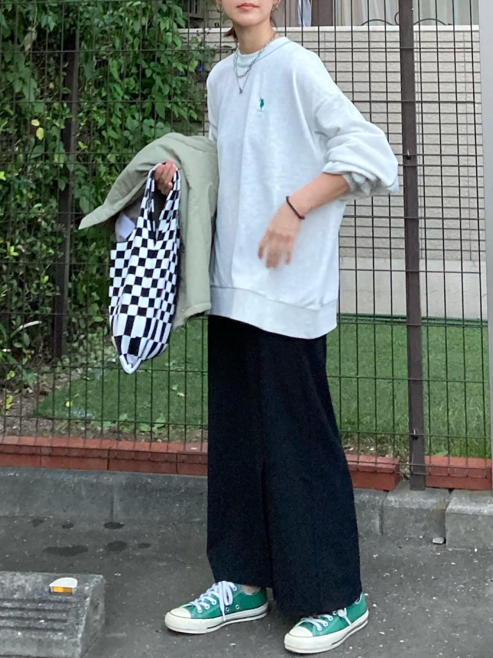 ベージュ系のスウェット、ブラック系のスカート、グリーン系のダウンジャケット/コートを着用したレディースの秋コーディネートの2枚目の写真