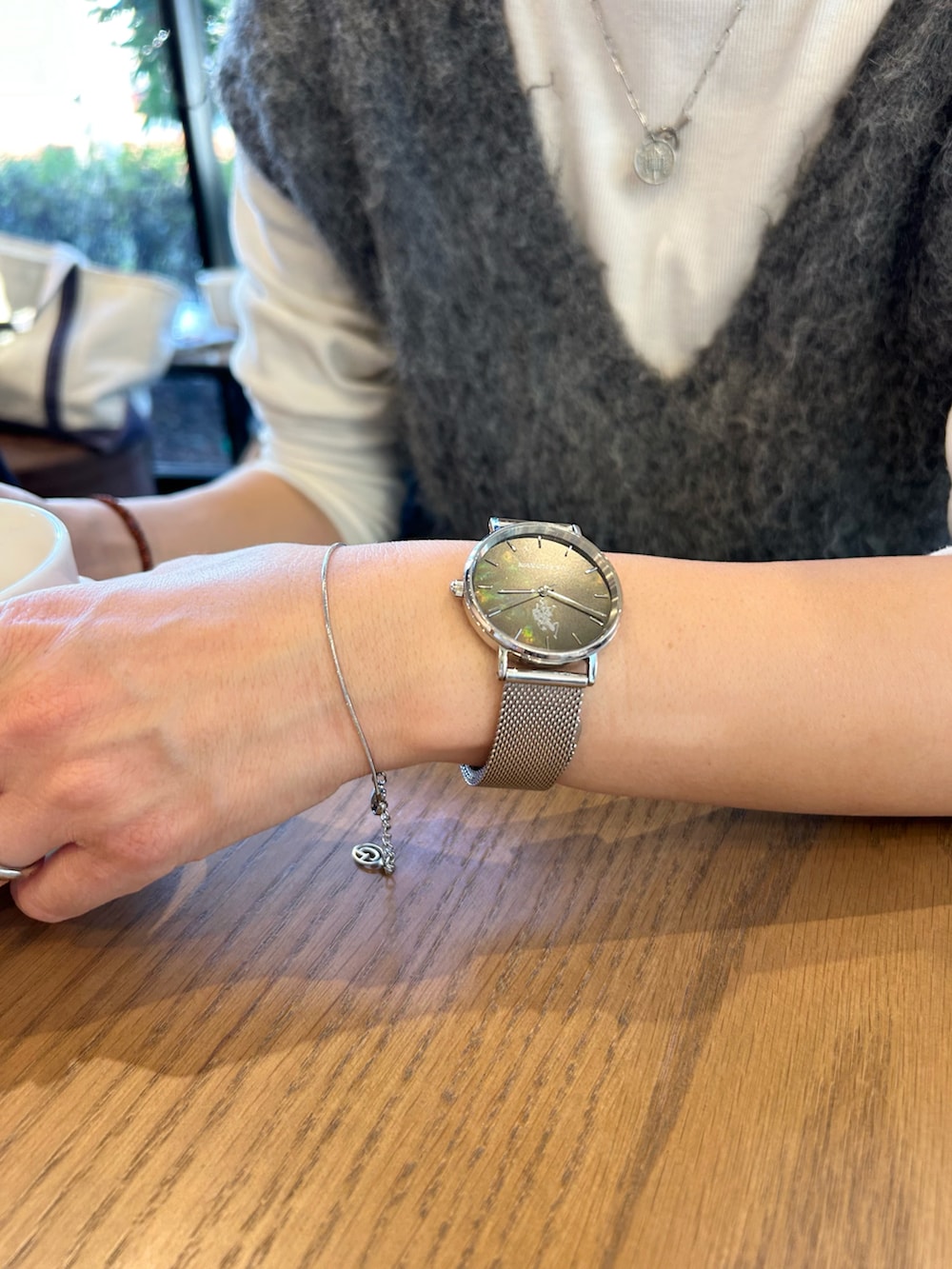 グリーン系のノーカラージャケット、グレー系のベスト、オレンジ系のトートバッグを着用したレディースの冬コーディネートの3枚目の写真