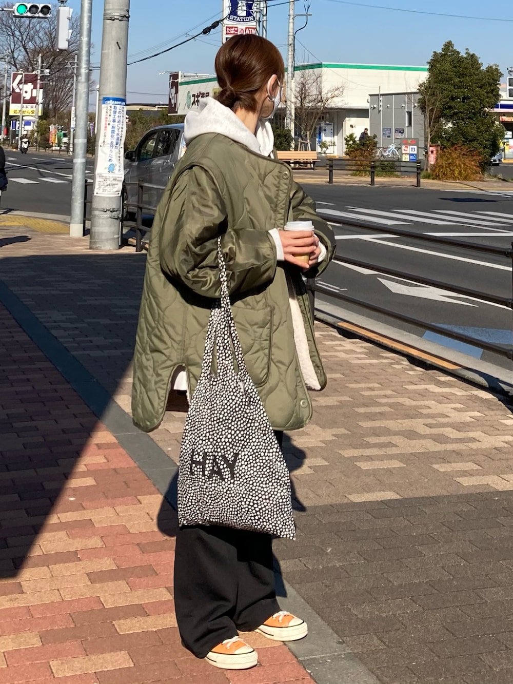 グリーン系のブルゾン、グレー系のパーカー、ブラック系のその他パンツを着用したレディースの冬コーディネートの2枚目の写真