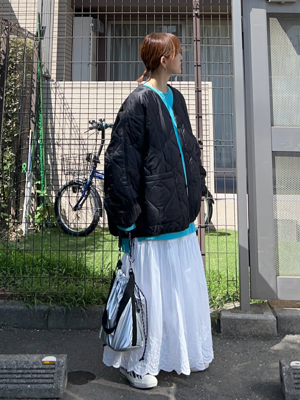 ホワイト系のスカート、シルバー系のトートバッグ、ブルー系のスウェットを着用したレディースの秋コーディネートの3枚目の写真