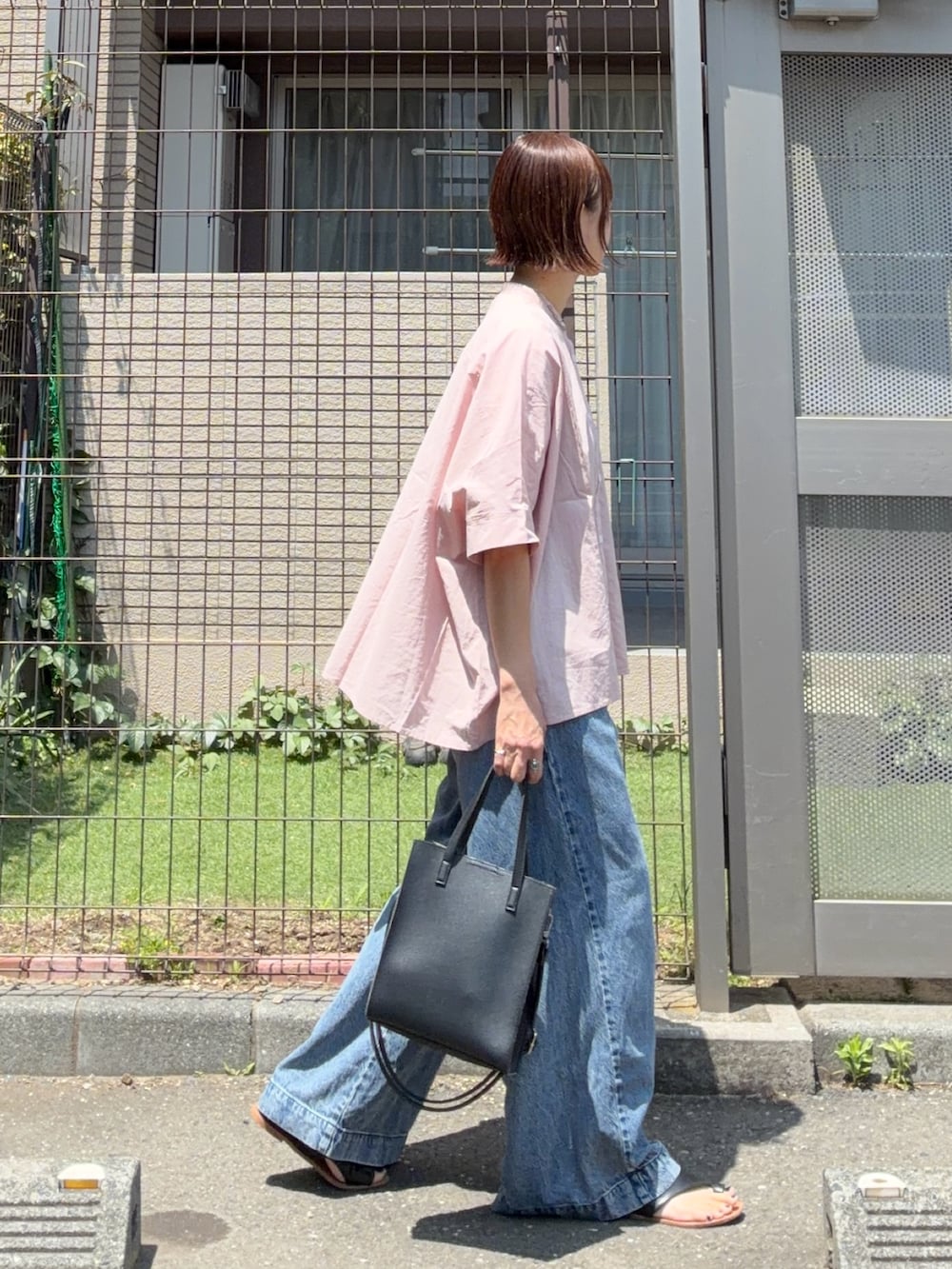 ピンク系のシャツ/ブラウス、ブルー系のデニムパンツ、ブラック系のショルダーバッグを着用したレディースの春コーディネートの4枚目の写真