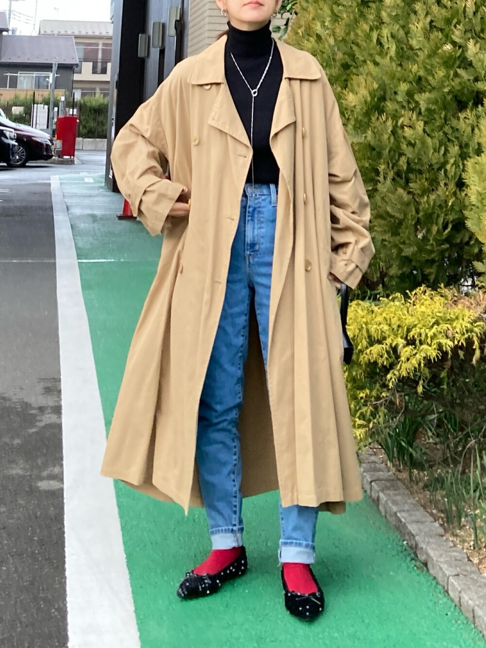 ブラック系のニット/セーター、ブルー系のデニムパンツ、ベージュ系のチェスターコートを着用したレディースの冬コーディネートの3枚目の写真