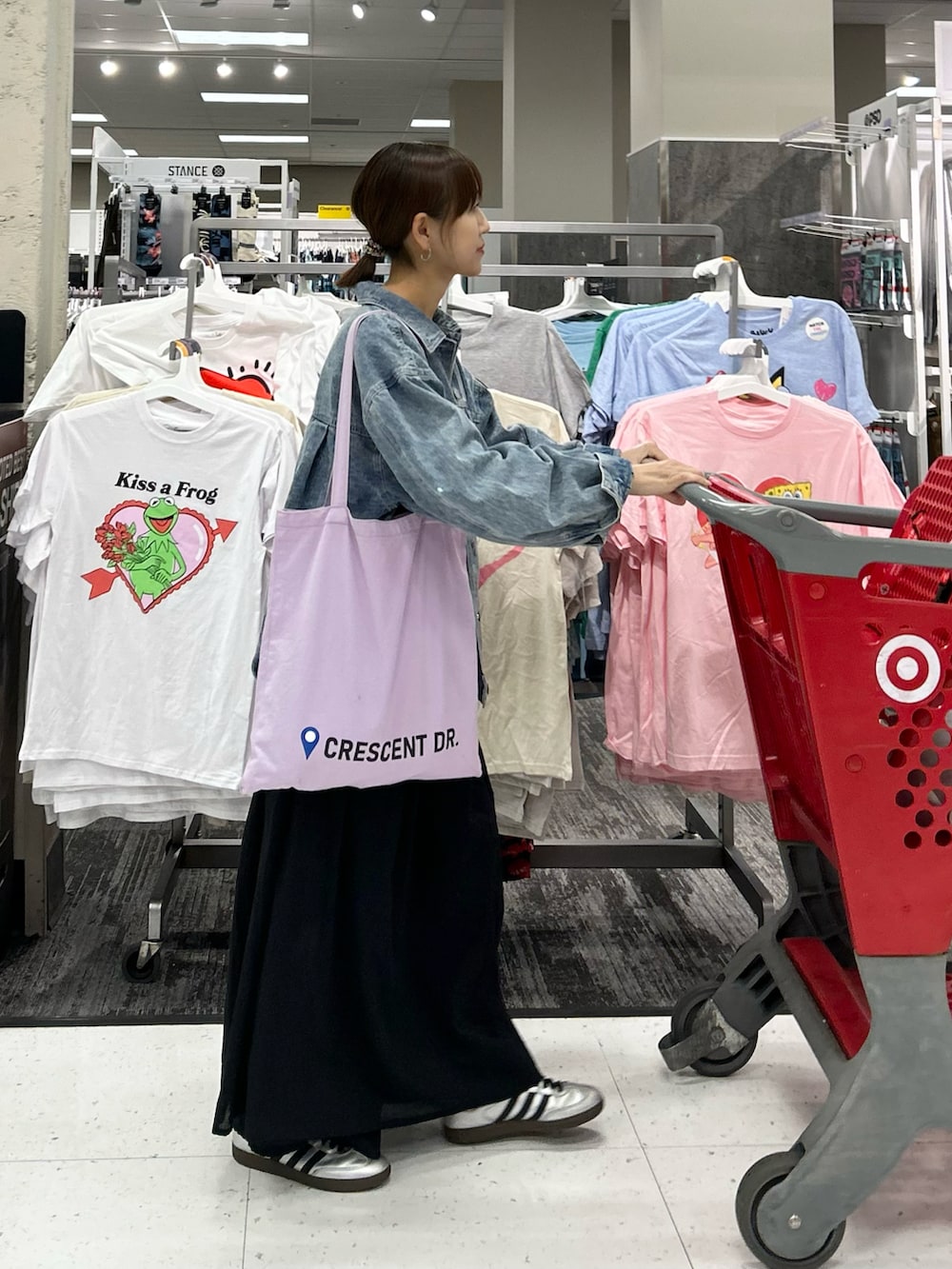 ブラック系のワンピース、ブルー系のデニムジャケット、パープル系のトートバッグを着用したレディースの春コーディネートの2枚目の写真