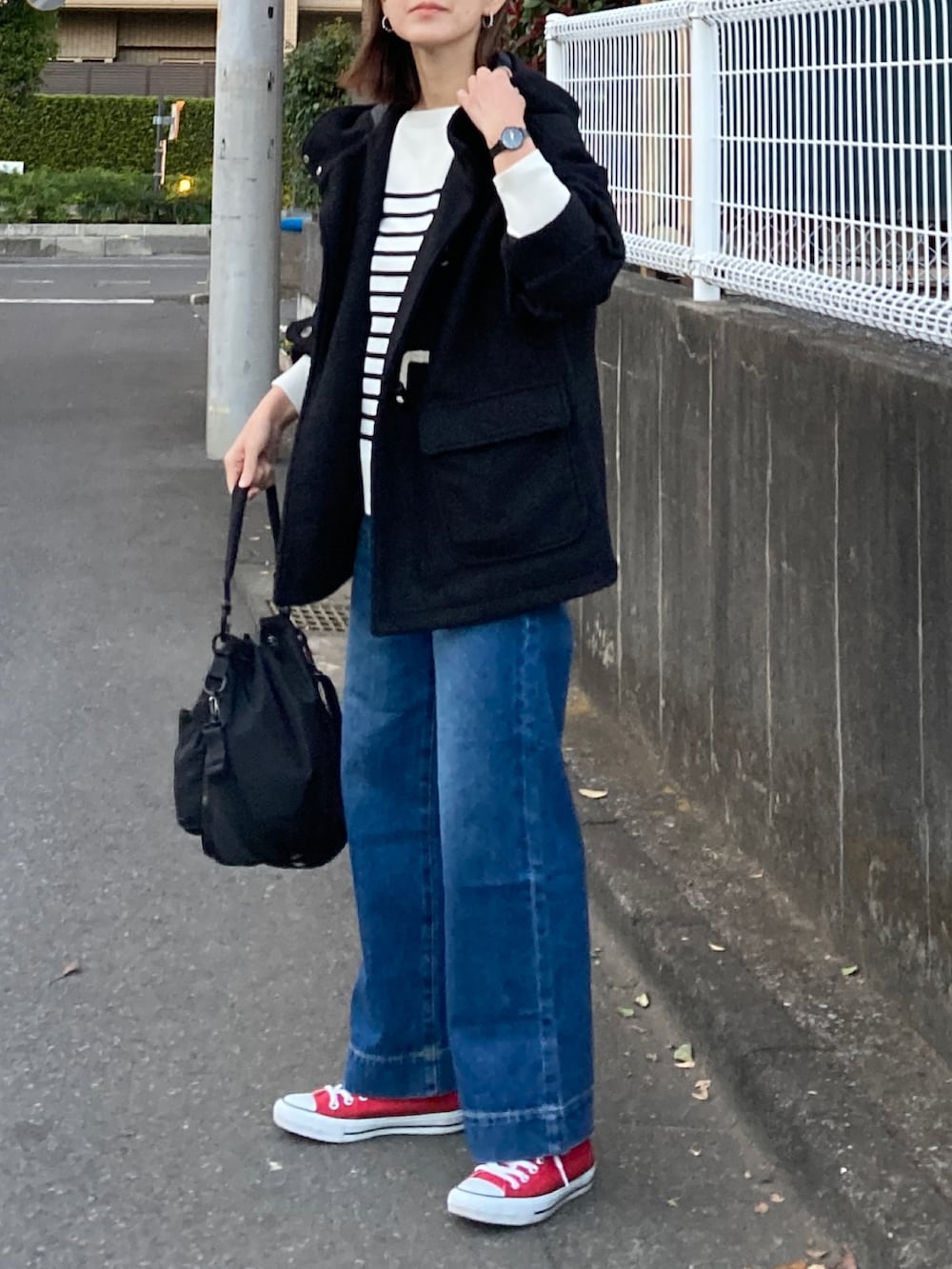 ブラック系のダッフルコート、ホワイト系のニット/セーター、ブラック系のショルダーバッグを着用したレディースの冬コーディネートの4枚目の写真