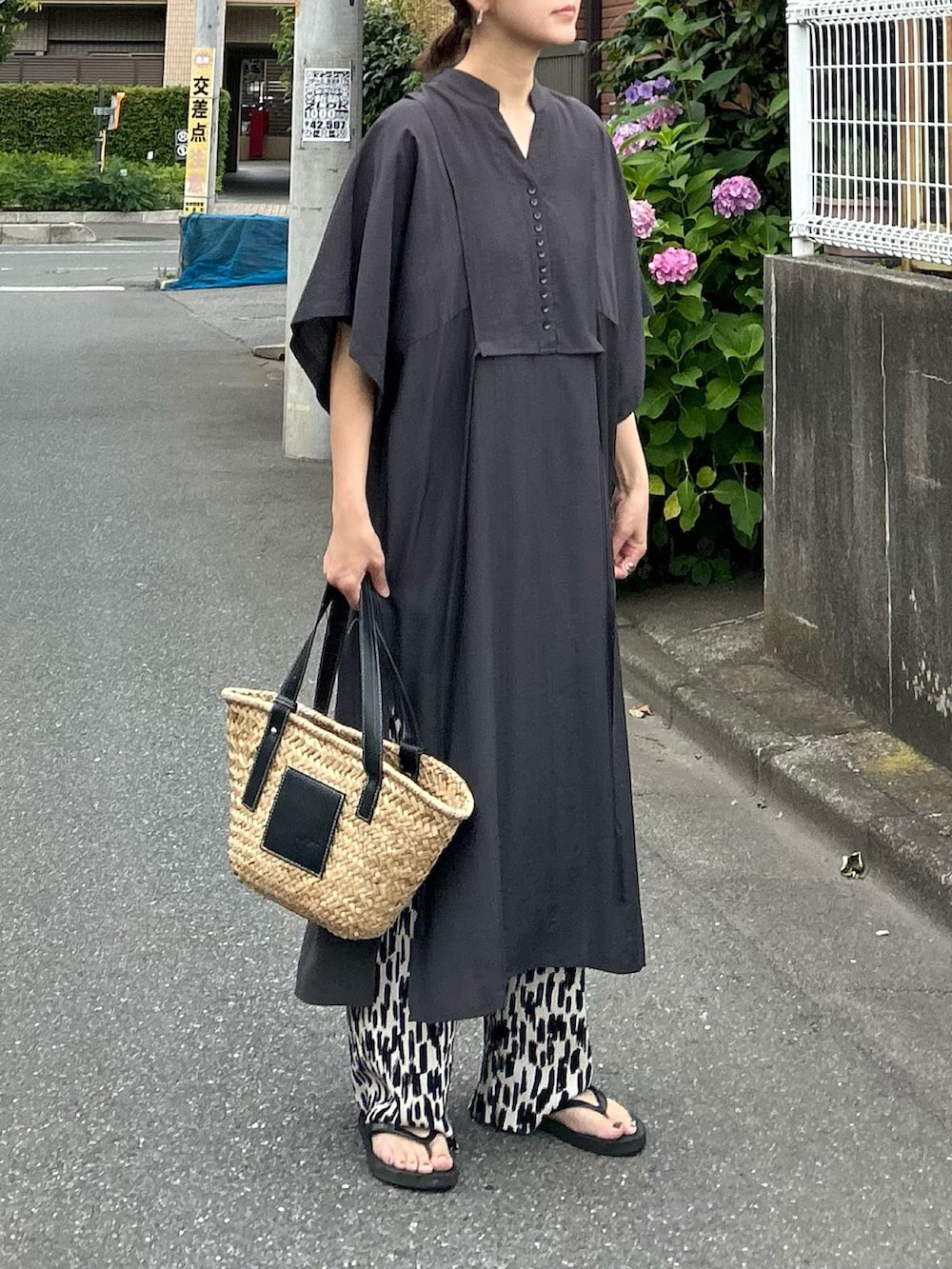 グレー系のシャツワンピース、ブラック系のかごバッグ、ホワイト系のその他パンツを着用したレディースの夏コーディネートの3枚目の写真