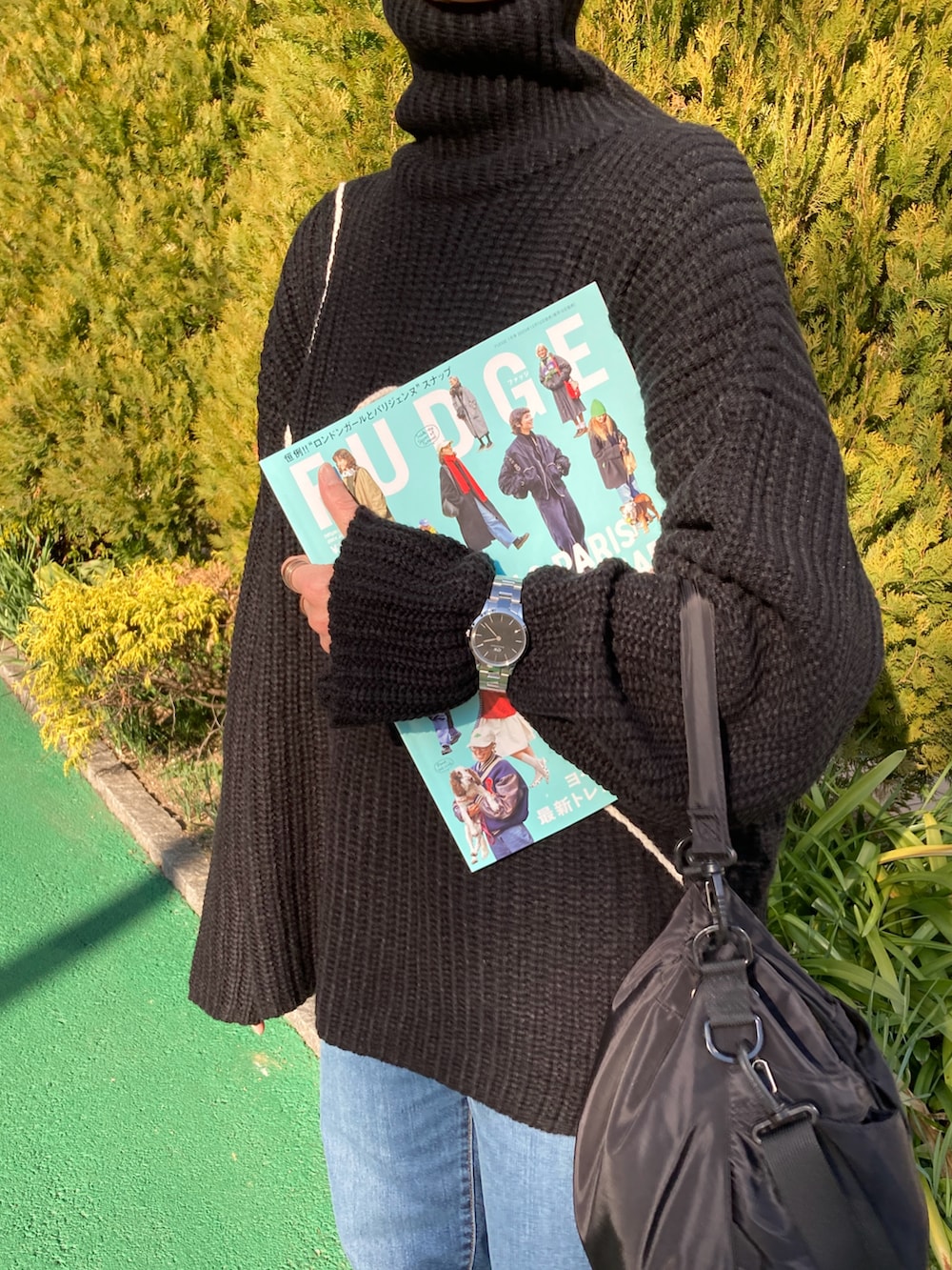 ブラック系のニット/セーター、ブルー系のデニムパンツ、ブラック系のショルダーバッグを着用したレディースの冬コーディネートの3枚目の写真