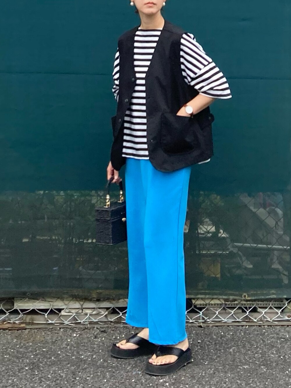 ブラック系のベスト、ブラック系のTシャツ/カットソー、ブルー系のスカートを着用したレディースの夏コーディネートの2枚目の写真