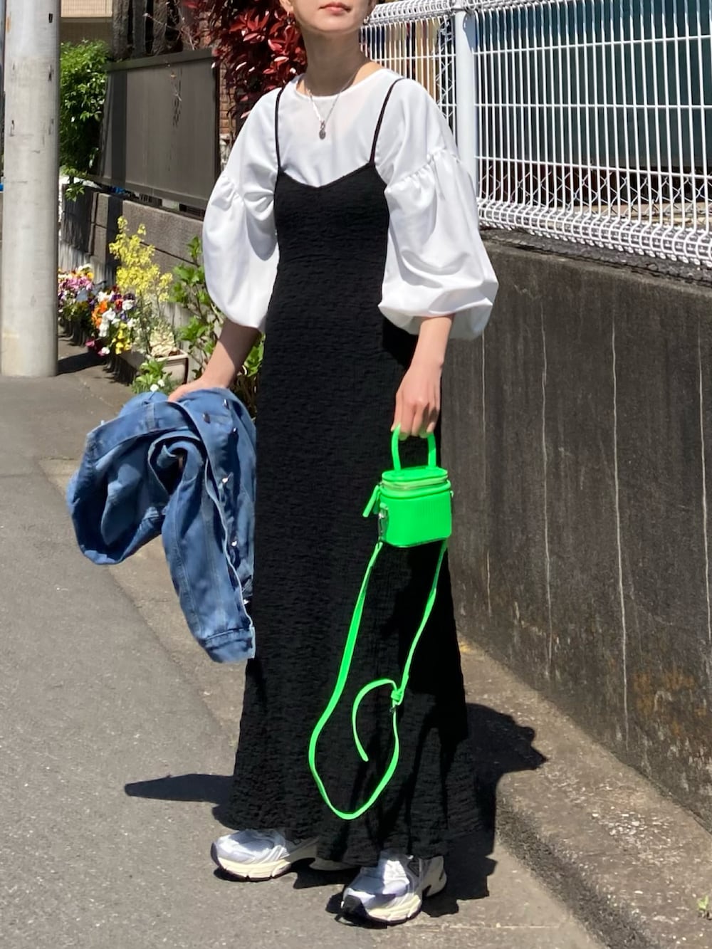 ブラック系のワンピース、ホワイト系のシャツ/ブラウス、グリーン系のショルダーバッグを着用したレディースの春コーディネートの2枚目の写真