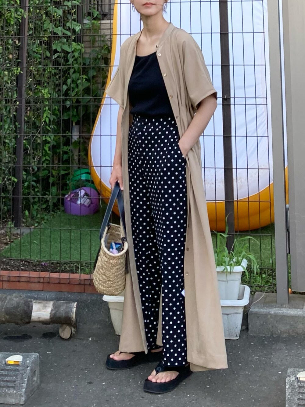 ベージュ系のワンピース、ブラック系のその他パンツ、ブラック系のかごバッグを着用したレディースの夏コーディネートの3枚目の写真