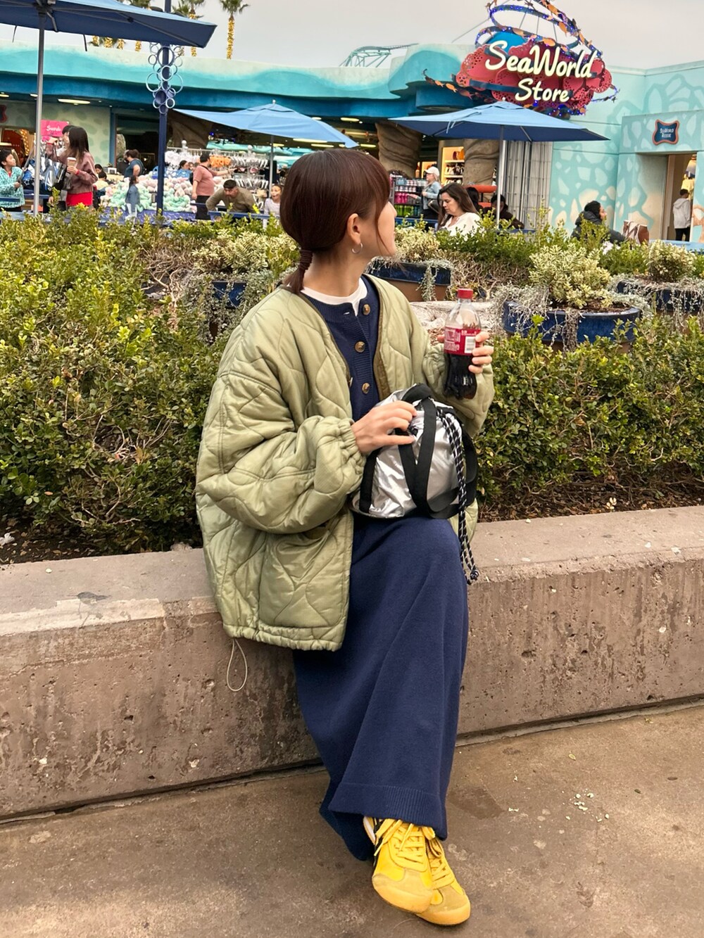 グリーン系のノーカラージャケット、ブルー系のワンピース、シルバー系のトートバッグを着用したレディースの冬コーディネートの3枚目の写真