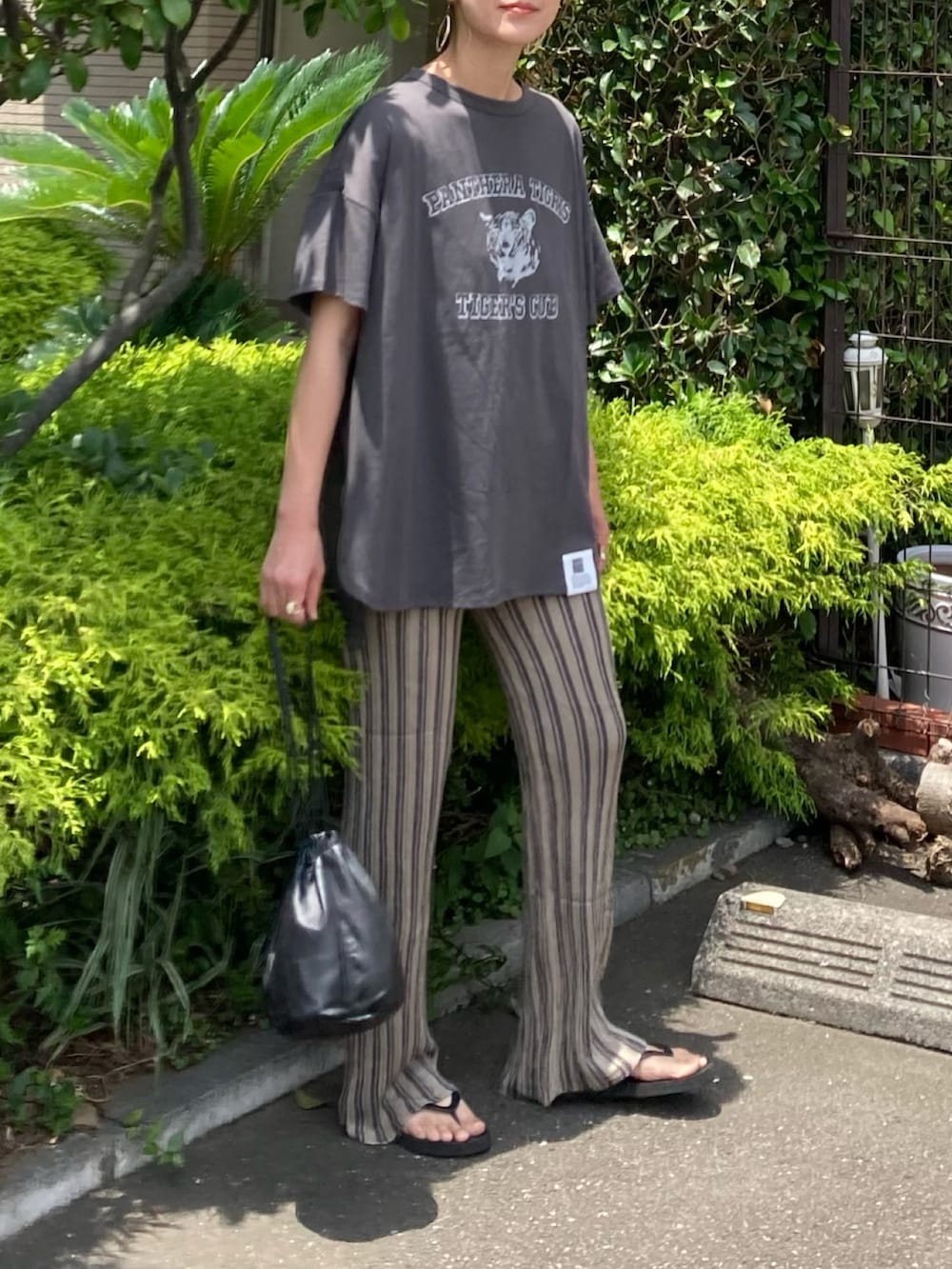 グレー系のTシャツ/カットソー、ベージュ系のその他パンツ、ブラック系のハンドバッグを着用したレディースの夏コーディネートの2枚目の写真