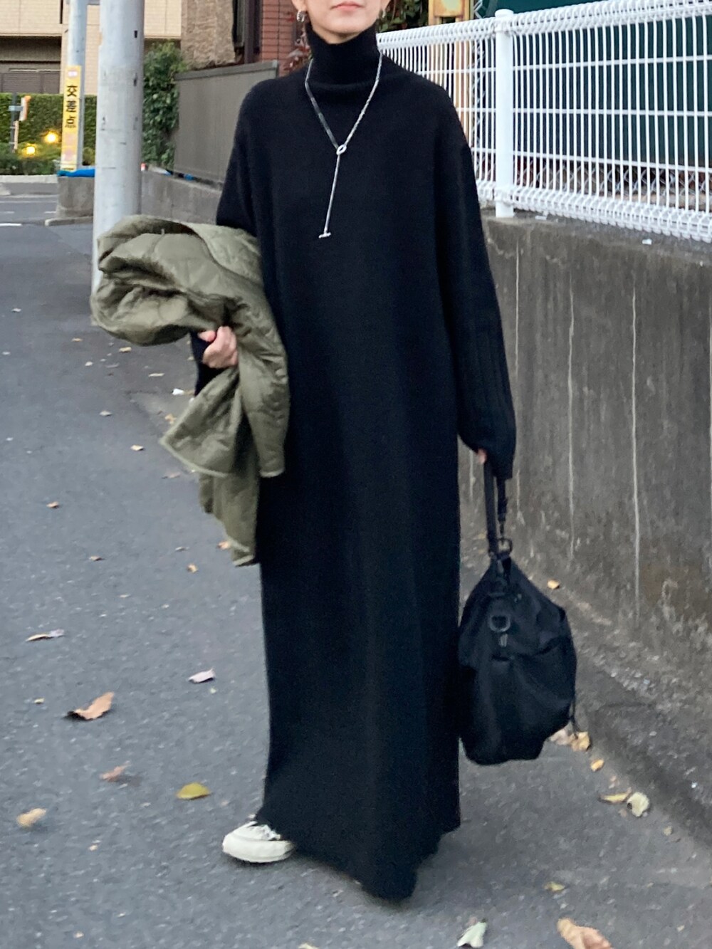 ブラック系のワンピース、ブラック系のショルダーバッグ、その他のスニーカーを着用したレディースの冬コーディネートの2枚目の写真