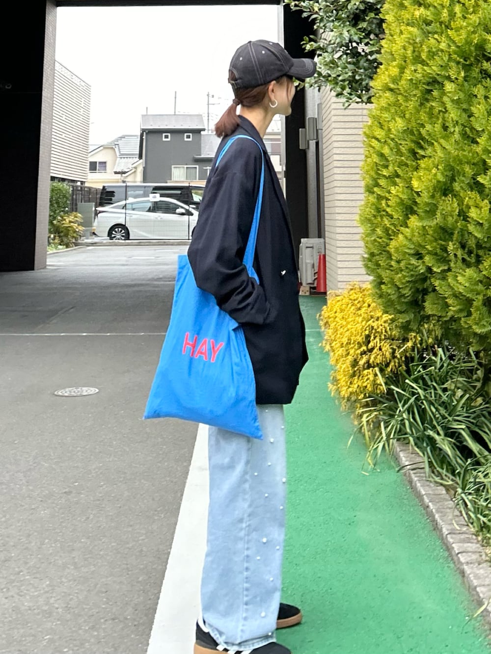 ホワイト系のTシャツ/カットソー、ブルー系のテーラードジャケット、ブルー系のデニムパンツを着用したレディースの春コーディネートの5枚目の写真