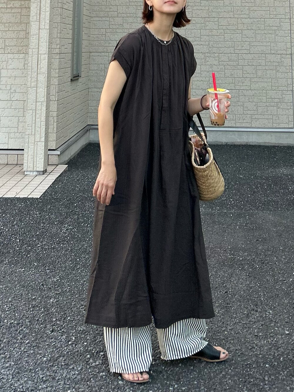 グレー系のワンピース、ブラック系のかごバッグ、ブルー系のその他パンツを着用したレディースの夏コーディネートの2枚目の写真