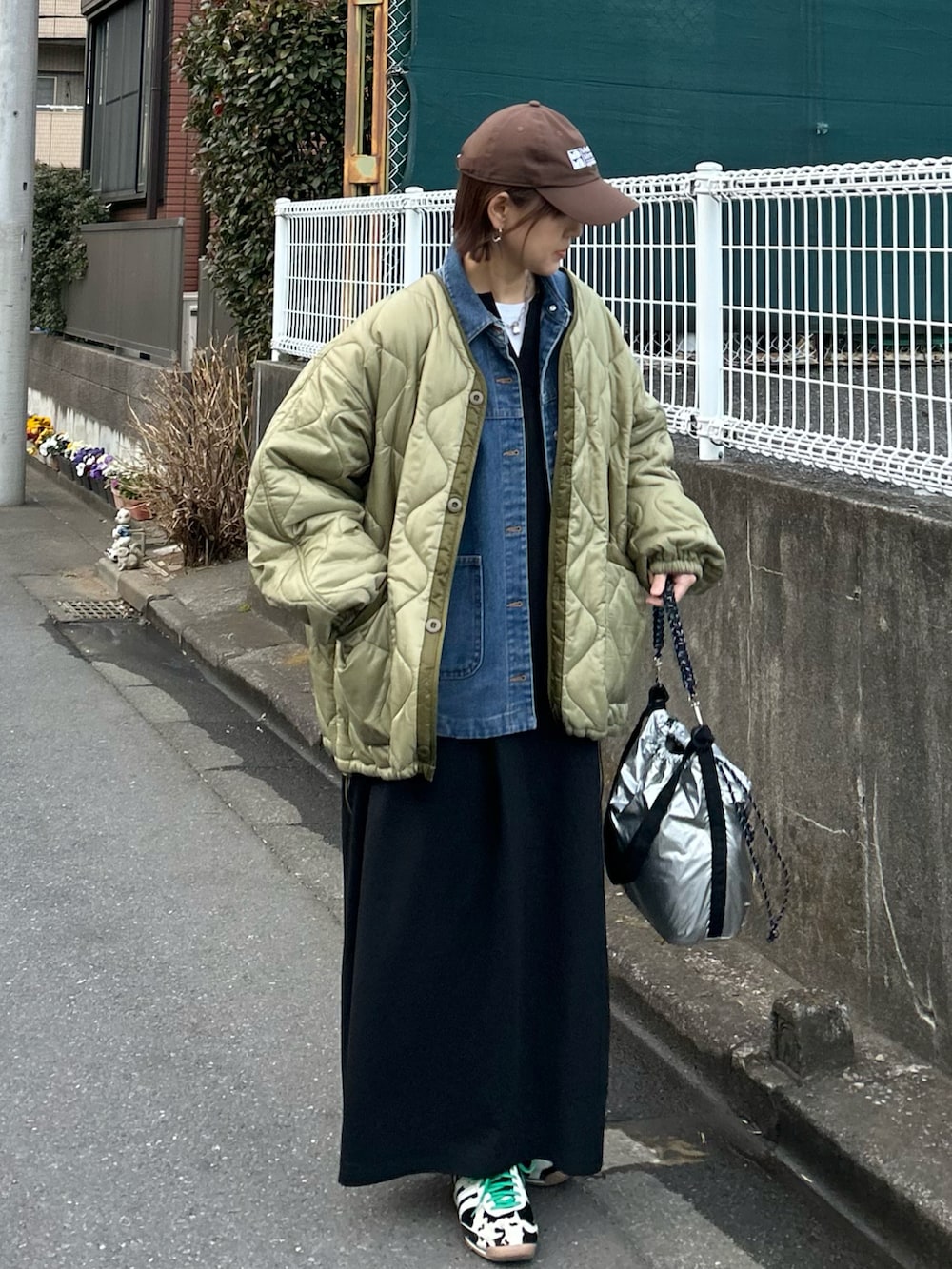 ブラック系のワンピース、グリーン系のブルゾン、ブルー系のデニムジャケットを着用したレディースの冬コーディネートの3枚目の写真