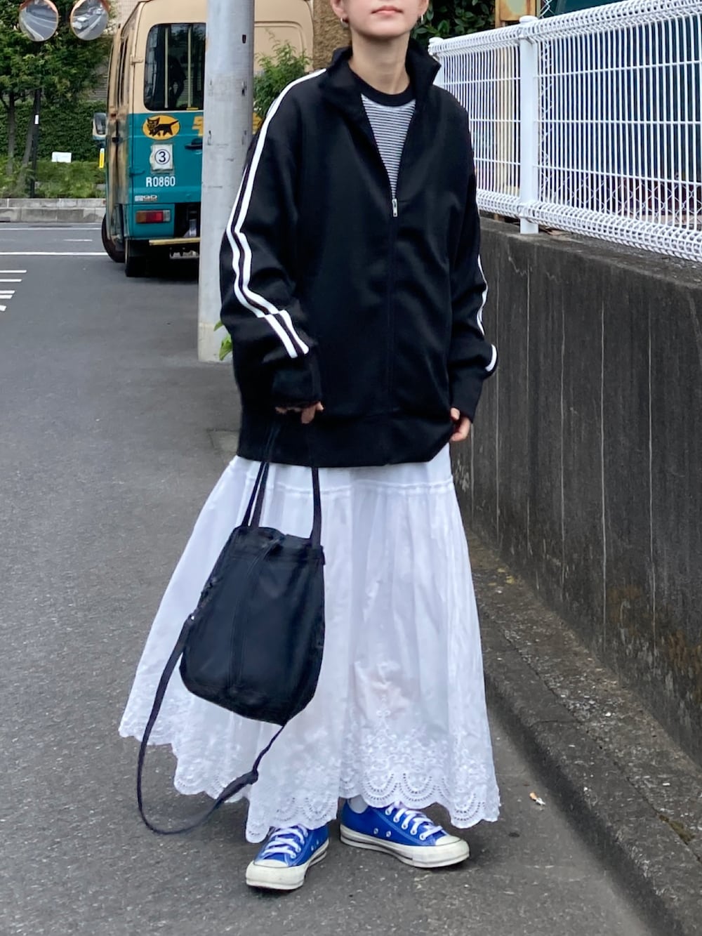 ブラック系のジャージ、ホワイト系のTシャツ/カットソー、ホワイト系のスカートを着用したレディースの夏コーディネートの3枚目の写真