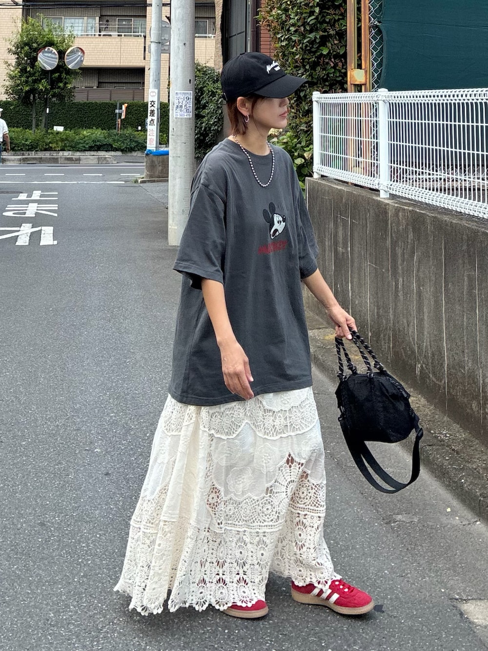 グレー系のTシャツ/カットソー、ホワイト系のスカート、ブラック系のトートバッグを着用したレディースの夏コーディネートの3枚目の写真