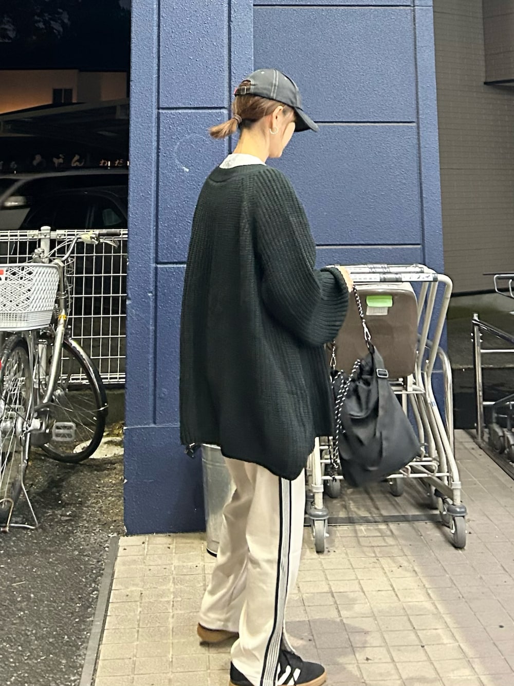 ブラック系のニット/セーター、ベージュ系のスウェットパンツ、ブラック系のトートバッグを着用したレディースの秋コーディネートの5枚目の写真