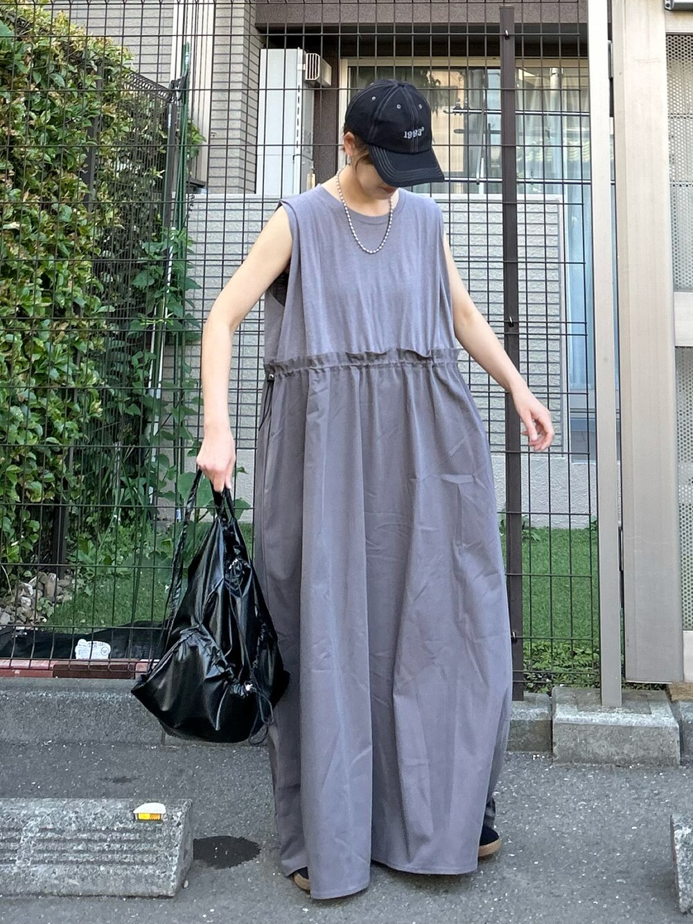 グレー系のワンピース、ブラック系のバックパック/リュック、ブラック系のキャップを着用したレディースの夏コーディネートの3枚目の写真