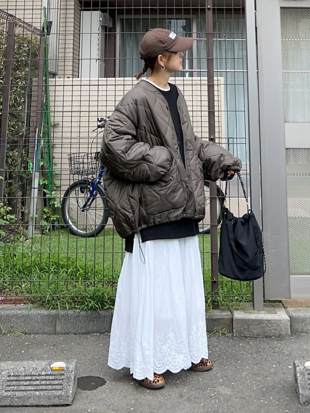 ホワイト系のスカート、ブラック系のトートバッグ、ブラック系のスウェットを着用したレディースの秋コーディネートの4枚目の写真