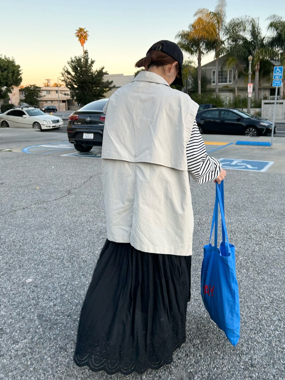 ホワイト系のTシャツ/カットソー、ホワイト系のブルゾン、ブラック系のスカートを着用したレディースの冬コーディネートの3枚目の写真