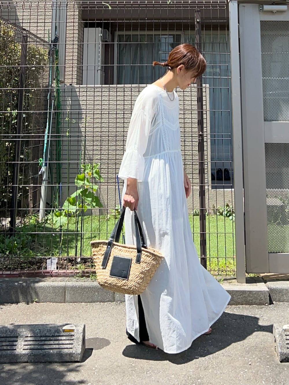 ホワイト系のワンピース、ブラック系のその他パンツ、ブラック系のかごバッグを着用したレディースの夏コーディネートの3枚目の写真