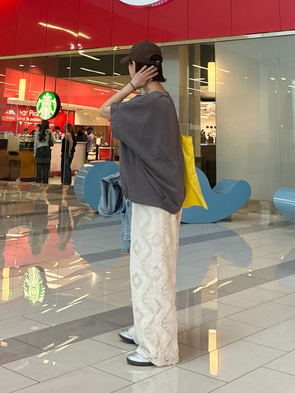 グレー系のTシャツ/カットソー、ホワイト系のスラックス、シルバー系のスニーカーを着用したレディースの春コーディネートの3枚目の写真