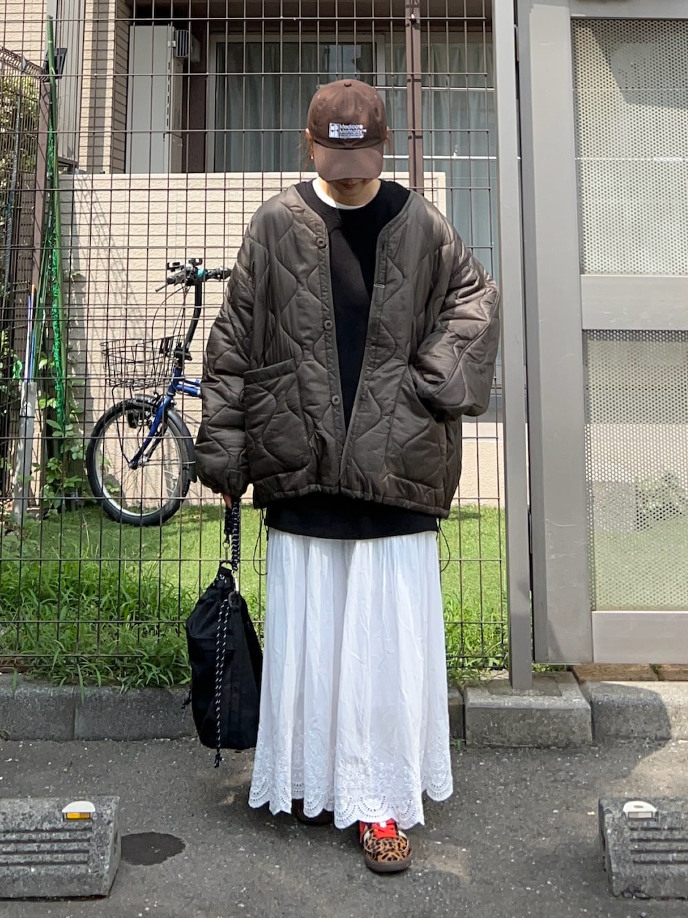 ホワイト系のスカート、ブラック系のトートバッグ、ブラック系のスウェットを着用したレディースの秋コーディネートの2枚目の写真