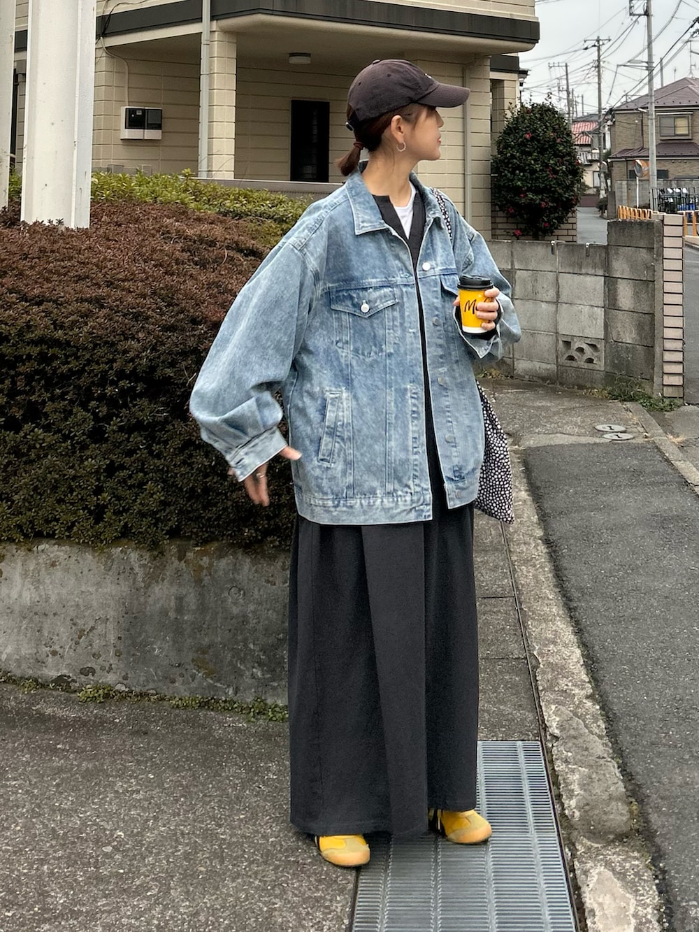 ブルー系のデニムジャケット、グレー系のワンピース、イエロー系のスニーカーを着用したレディースの冬コーディネートの3枚目の写真