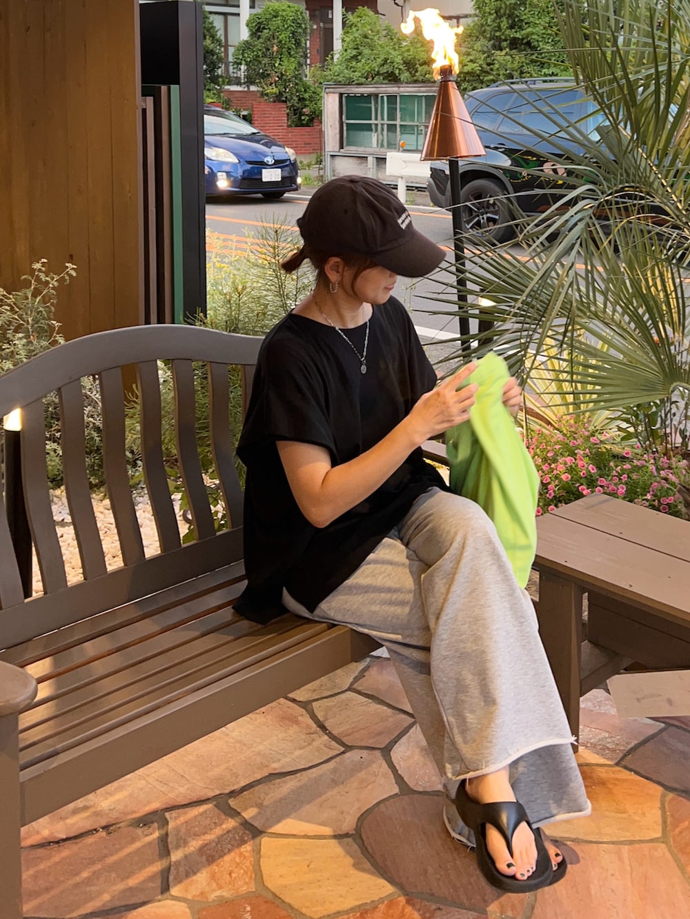 ブラック系のTシャツ/カットソー、グレー系のスウェットパンツ、グリーン系のトートバッグを着用したレディースの夏コーディネートの3枚目の写真