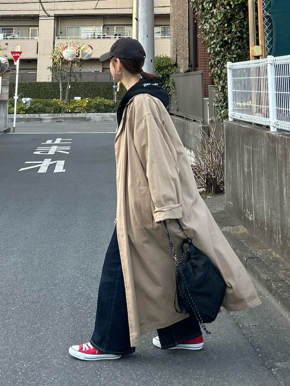 ホワイト系のニット/セーター、ブルー系のデニムパンツ、ブラック系のトートバッグを着用したレディースの春コーディネートの4枚目の写真