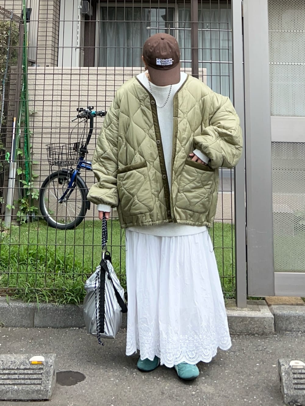 ホワイト系のスカート、シルバー系のトートバッグ、グリーン系のスニーカーを着用したレディースの秋コーディネートの4枚目の写真