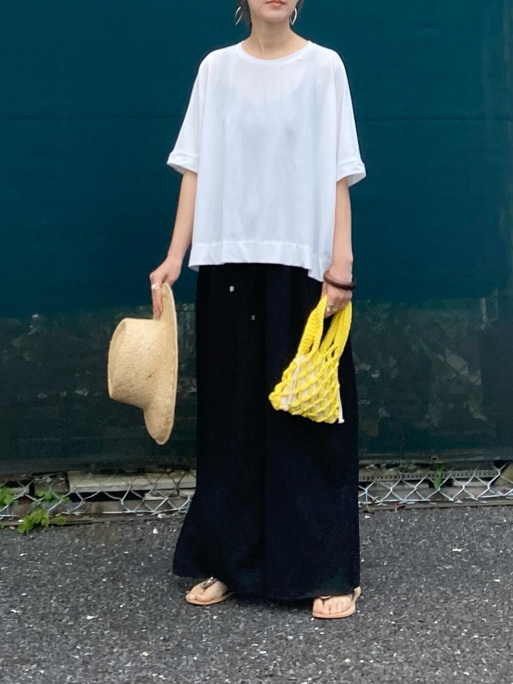 ホワイト系のTシャツ/カットソー、ブラック系のその他パンツ、イエロー系のハンドバッグを着用したレディースの春コーディネートの2枚目の写真