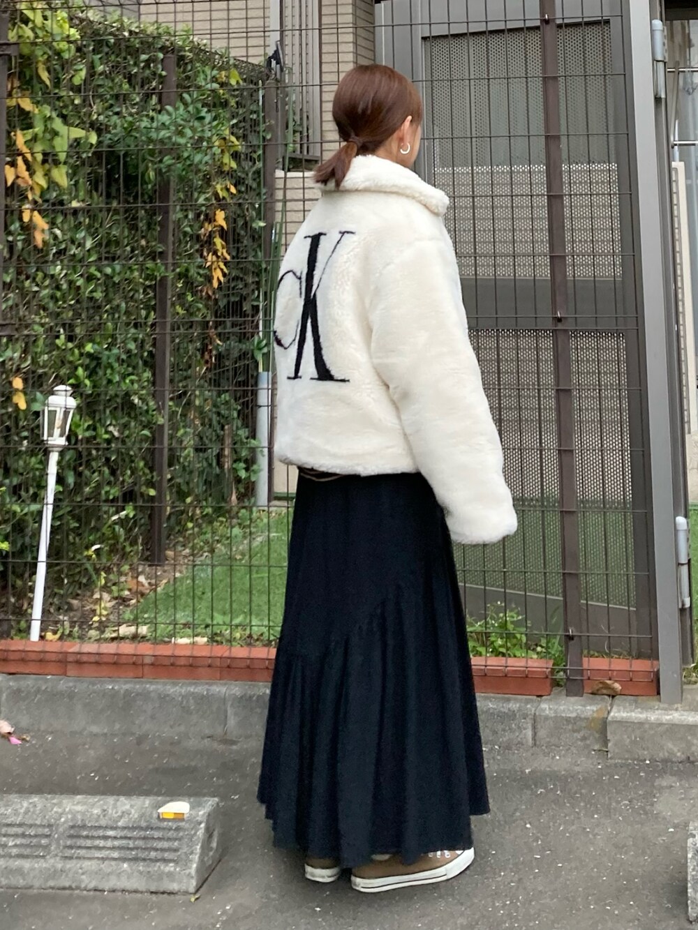 ホワイト系のその他アウター、ブラック系のTシャツ/カットソー、ブラック系のスカートを着用したレディースの秋コーディネートの2枚目の写真