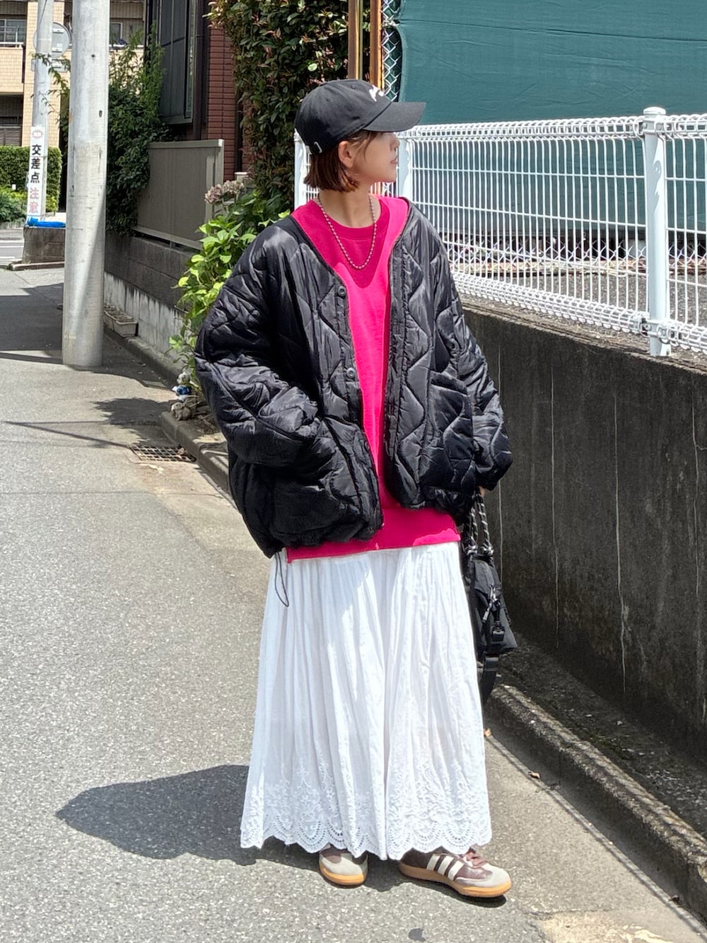 ブラック系のトートバッグ、ブラック系のブルゾン、ブラック系のキャップを着用したレディースの夏コーディネートの2枚目の写真