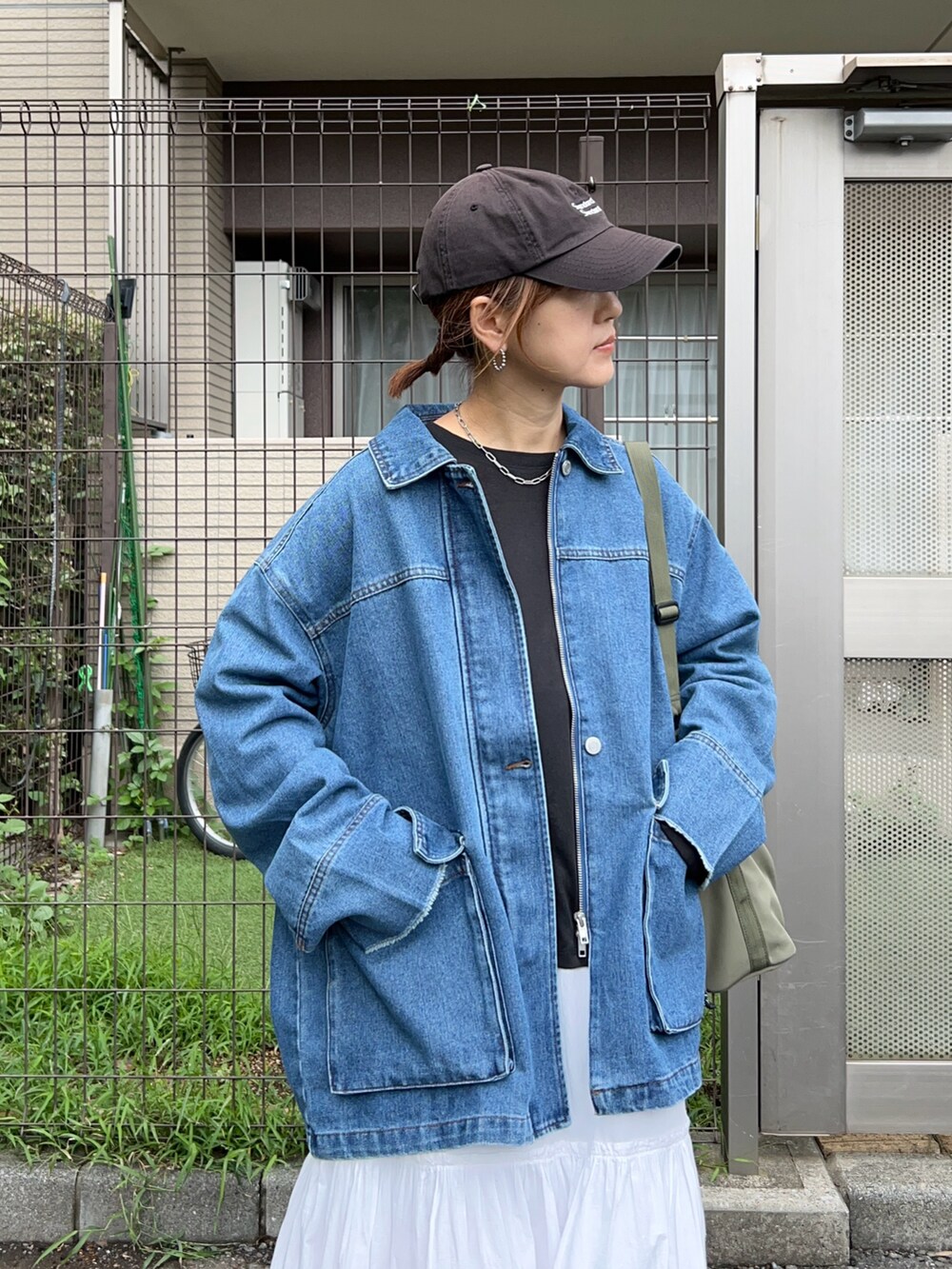 ブラック系のTシャツ/カットソー、ブルー系のデニムジャケット、グリーン系のトートバッグを着用したレディースの秋コーディネートの3枚目の写真