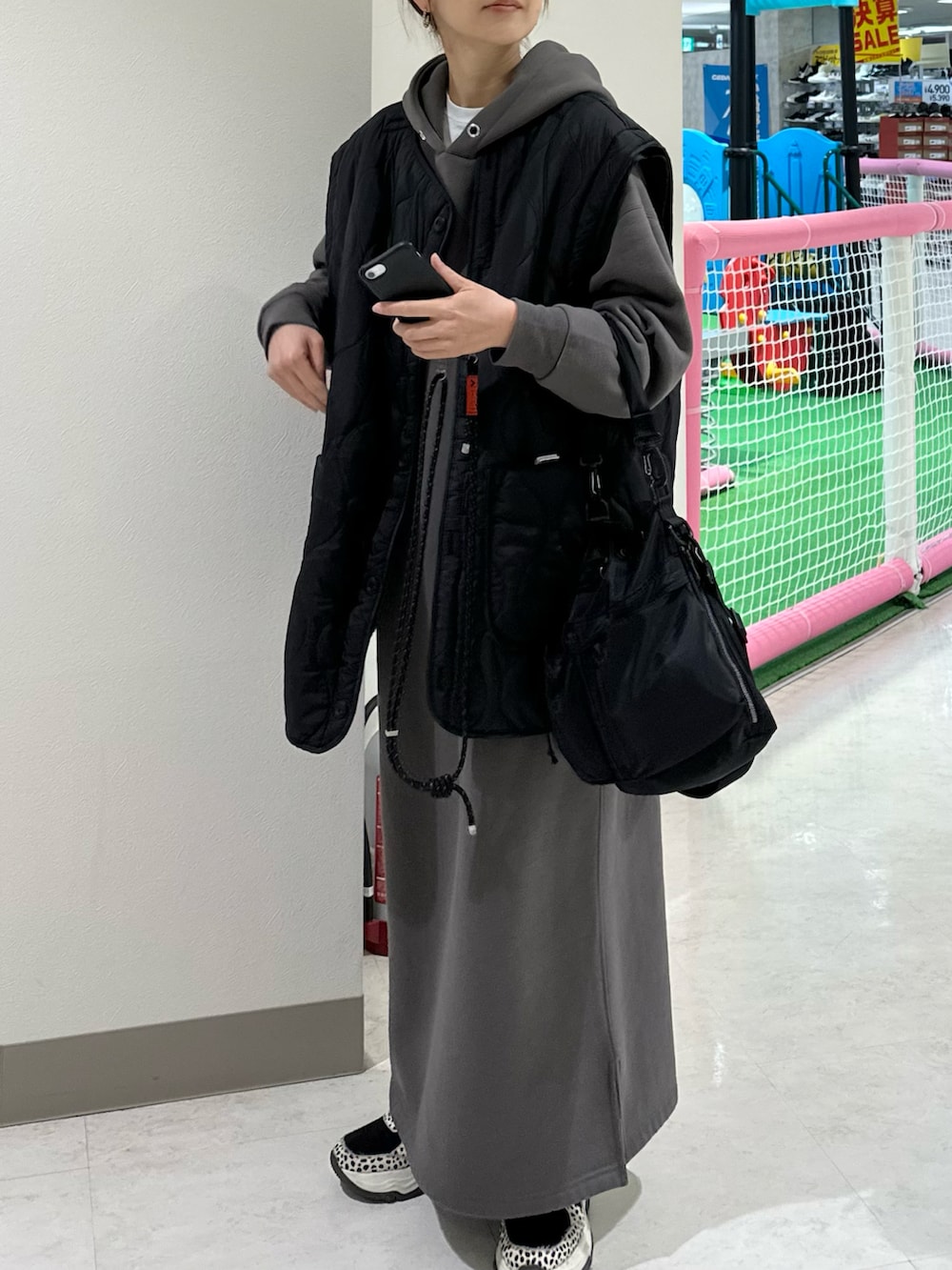 ブラック系のブルゾン、グレー系のワンピース、ブラック系のショルダーバッグを着用したレディースの冬コーディネートの2枚目の写真