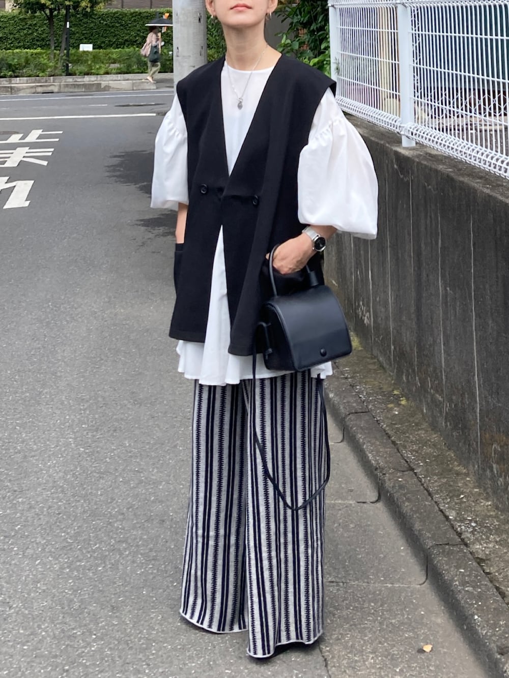 ブラック系のベスト、ホワイト系のシャツ/ブラウス、グレー系のその他パンツを着用したレディースの秋コーディネートの3枚目の写真