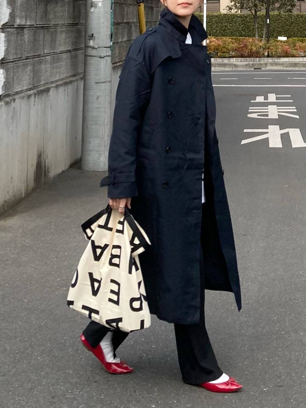 ブルー系のトレンチコート、ブラック系のTシャツ/カットソー、ホワイト系のトートバッグを着用したレディースの冬コーディネートの4枚目の写真