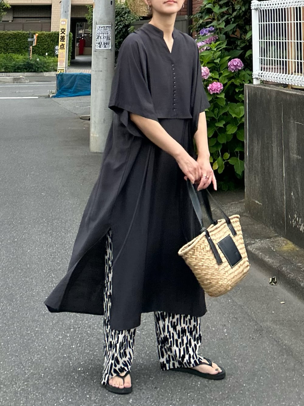 グレー系のシャツワンピース、ブラック系のかごバッグ、ホワイト系のその他パンツを着用したレディースの夏コーディネートの2枚目の写真