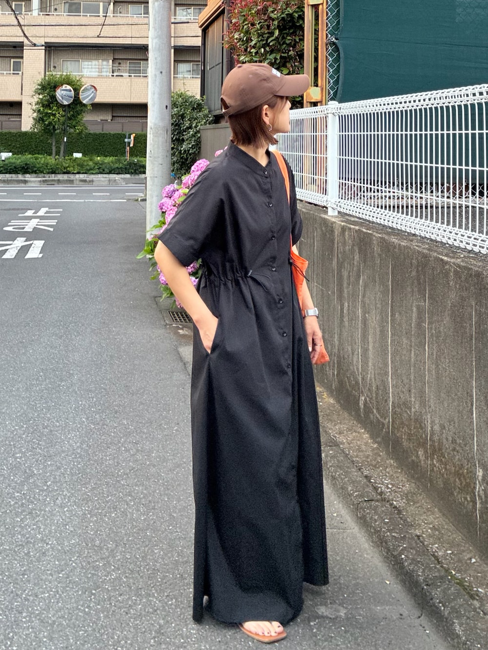 ブラック系のシャツワンピース、オレンジ系のトートバッグを着用したレディースの夏コーディネートの5枚目の写真