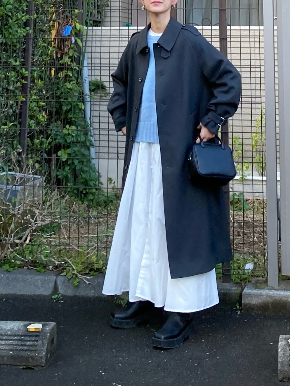 グレー系のその他アウター、ブルー系のニット/セーター、ホワイト系のシャツワンピースを着用したレディースの冬コーディネートの4枚目の写真