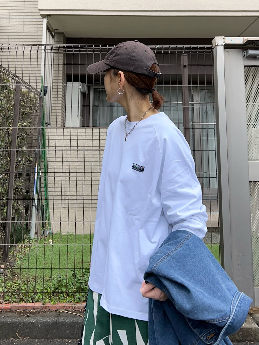 ホワイト系のTシャツ/カットソー、ブラック系のトートバッグ、ブルー系のデニムジャケットを着用したレディースの冬コーディネートの4枚目の写真