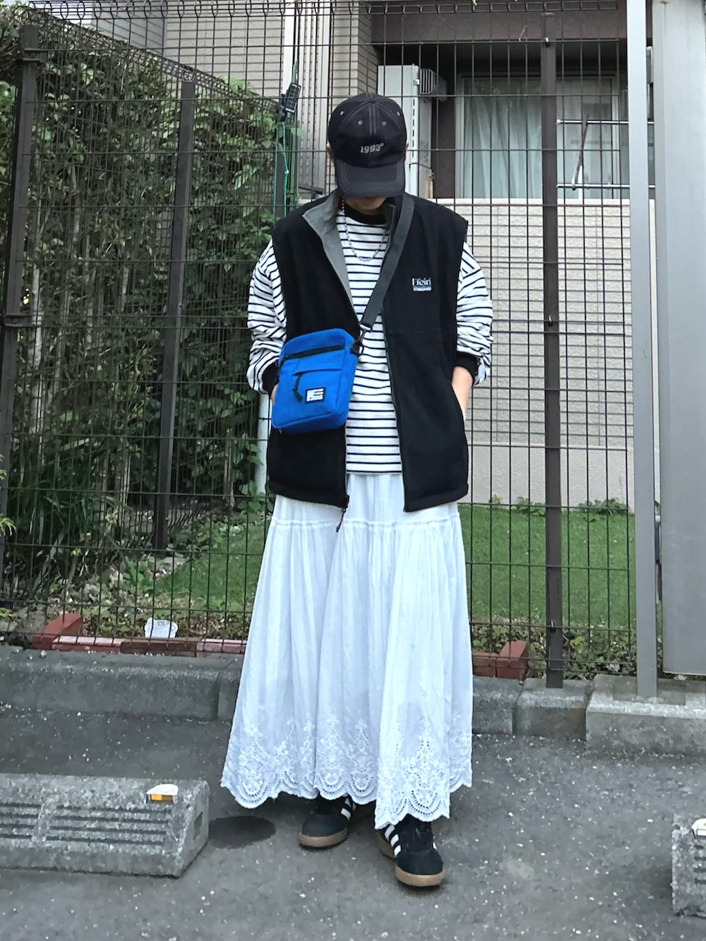 ブラック系のベスト、ブルー系のショルダーバッグ、ブラック系のTシャツ/カットソーを着用したレディースの秋コーディネートの2枚目の写真