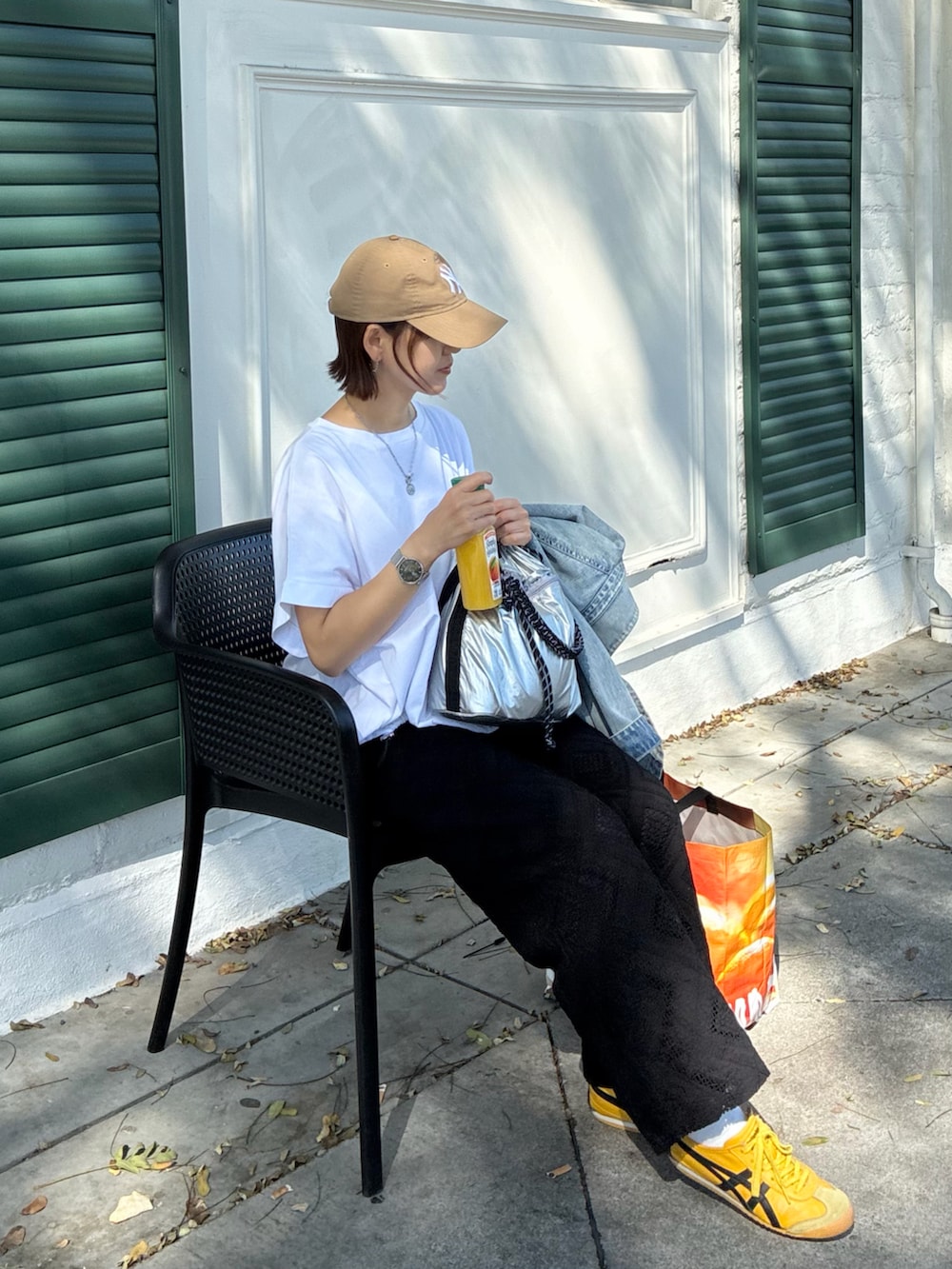 ホワイト系のTシャツ/カットソー、ブラック系のその他パンツ、シルバー系のショルダーバッグを着用したレディースの夏コーディネートの4枚目の写真