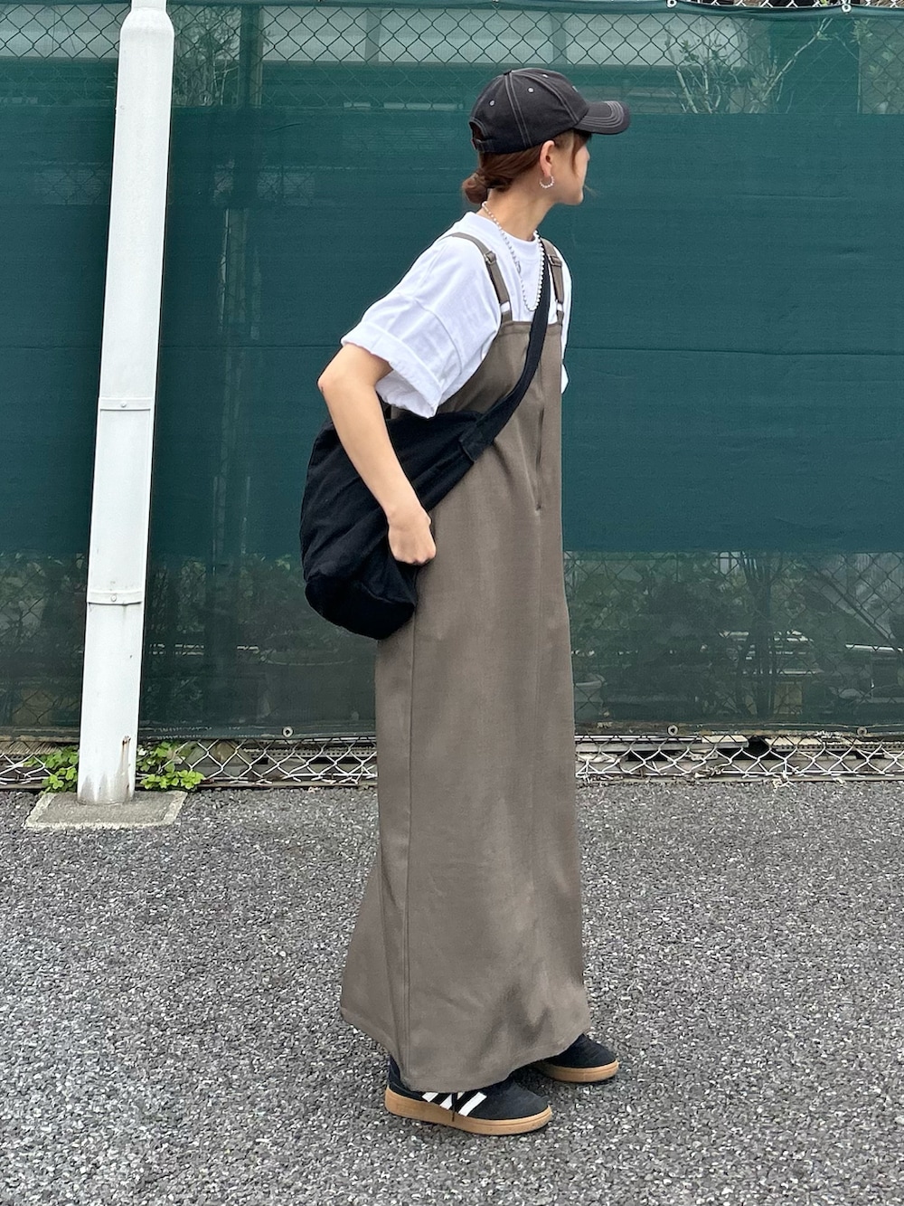 ベージュ系のワンピース、ホワイト系のTシャツ/カットソー、ブラック系のショルダーバッグを着用したレディースの春コーディネートの4枚目の写真