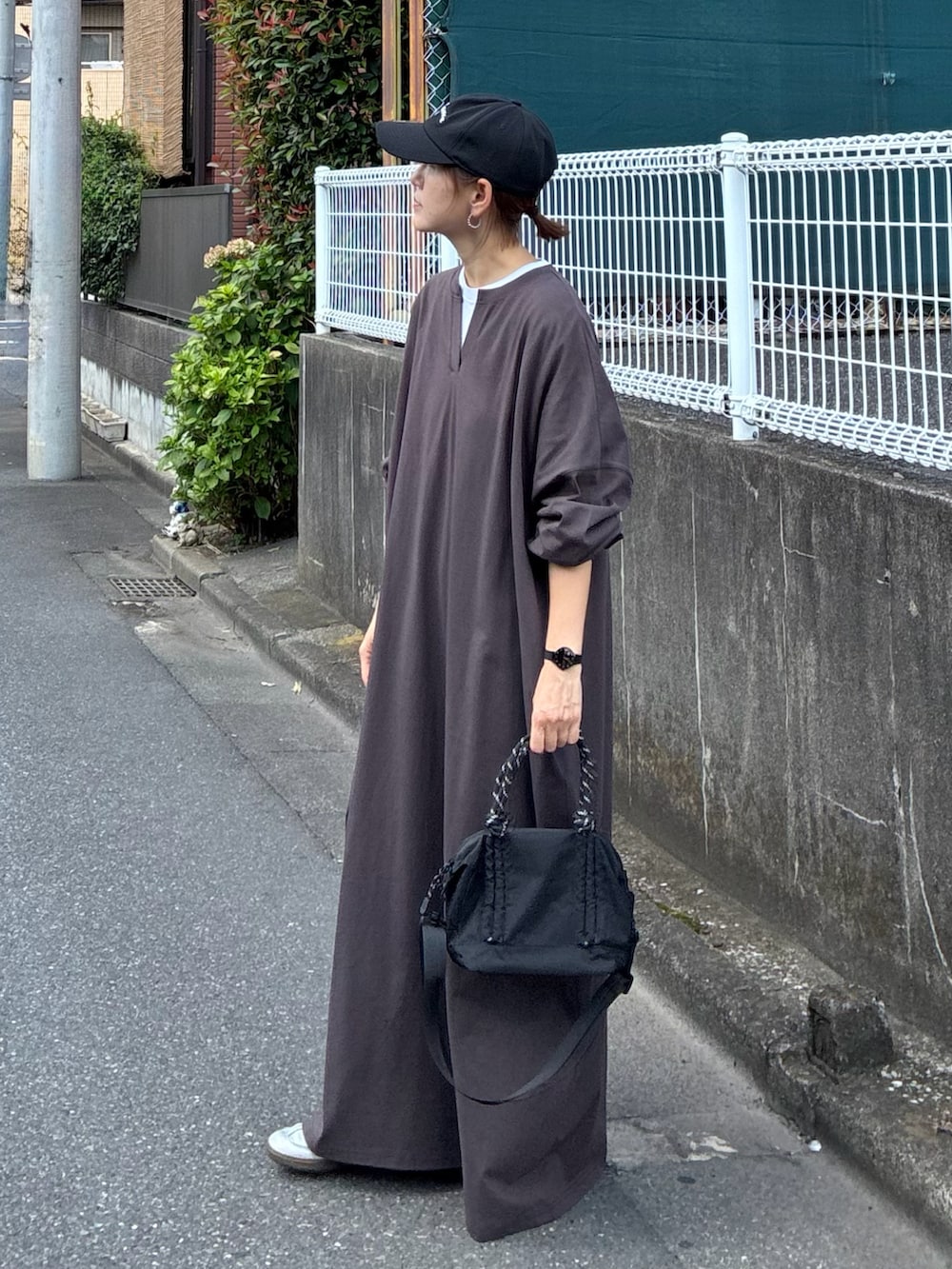 ブラウン系のワンピース、ブラック系のトートバッグ、ブラック系のキャップを着用したレディースの秋コーディネートの2枚目の写真