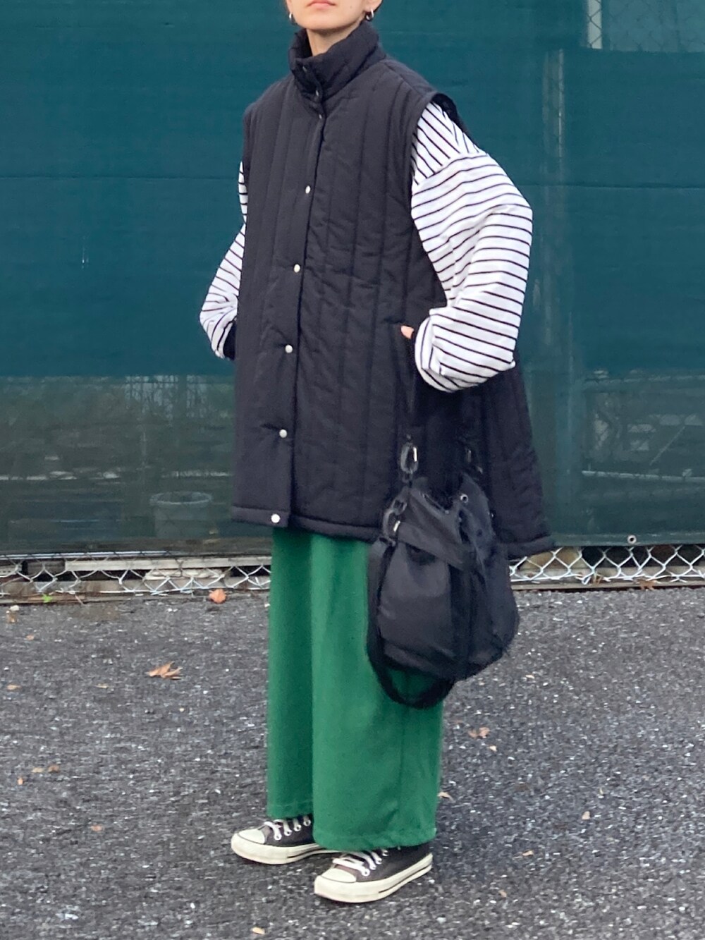 ブラック系のブルゾン、ブラック系のTシャツ/カットソー、ブラック系のショルダーバッグを着用したレディースの秋コーディネートの4枚目の写真